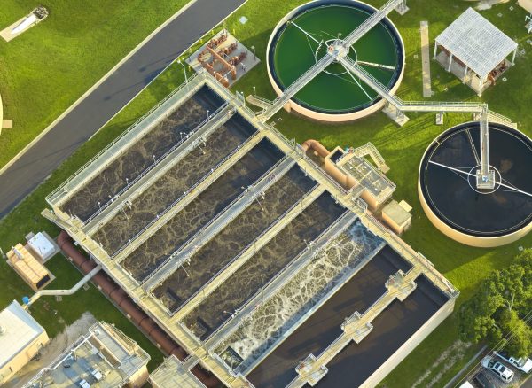 Aerial view of modern water cleaning facility at urban wastewater treatment plant. Purification process of removing undesirable chemicals, suspended solids and gases from contaminated liquid.