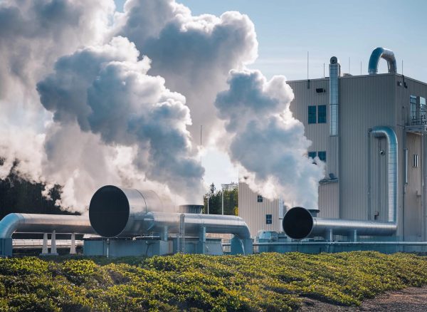 large-white-smoke-stack-with-blue-sky-trees-background